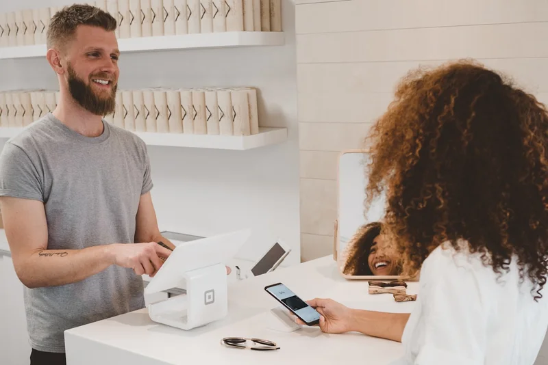 Friendly staff member assisting a customer at the counter